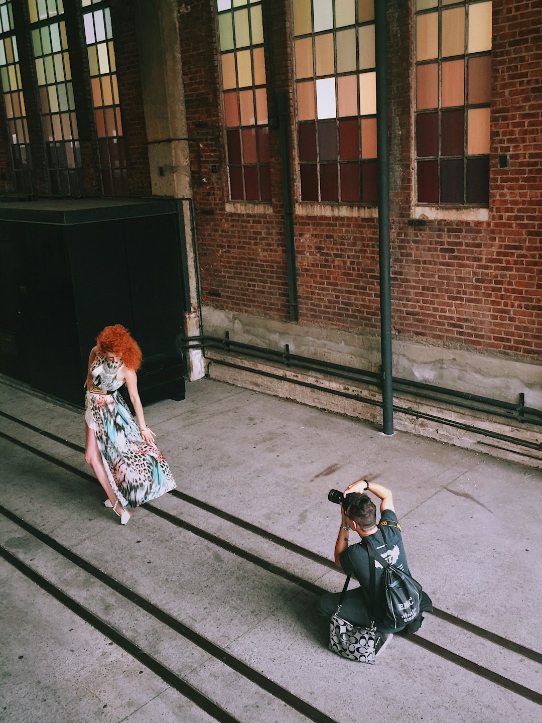Un fotografo in ginocchio cattura una modella con un vestito fantasia.