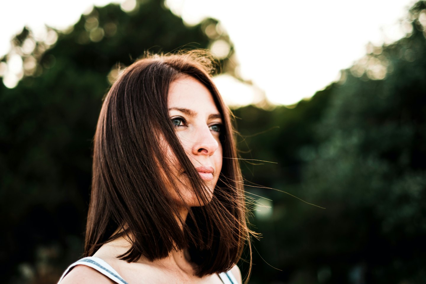 Donna che guarda intensamente altrove con i capelli scompigliati dal vento.